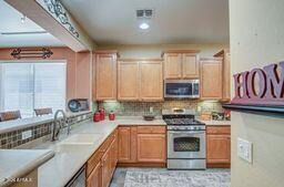 kitchen featuring sink, stainless steel appliances, and backsplash