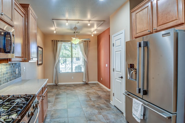 kitchen featuring ceiling fan, premium appliances, tasteful backsplash, and track lighting