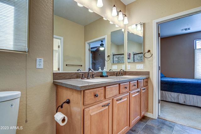 bathroom featuring toilet, vanity, tile patterned floors, and ceiling fan