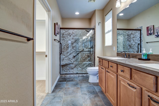 bathroom featuring vanity, toilet, and a shower with shower door