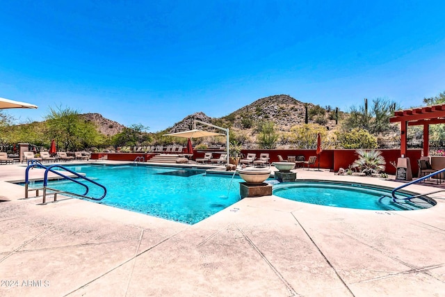 view of pool featuring a mountain view, a patio area, and a jacuzzi