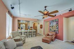 living room with track lighting, carpet flooring, and ceiling fan