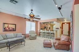 carpeted living room with ceiling fan