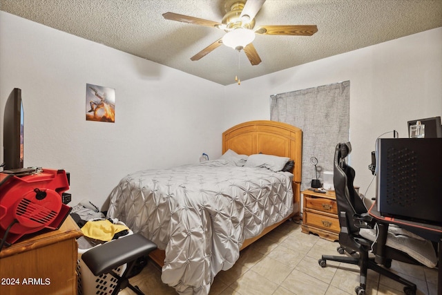 tiled bedroom with ceiling fan and a textured ceiling