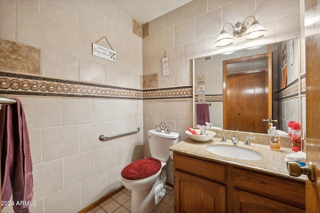 bathroom with vanity, toilet, and tile walls