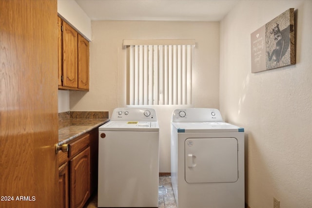 laundry room with washer and dryer and cabinets