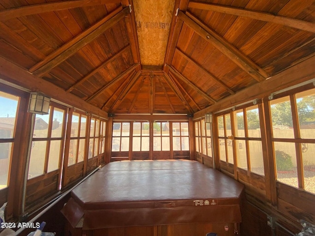 unfurnished sunroom featuring wood ceiling, a wealth of natural light, and vaulted ceiling with beams