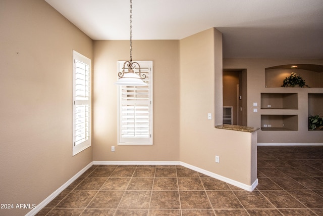 tiled spare room featuring built in features