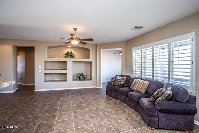 tiled living room featuring built in features and ceiling fan