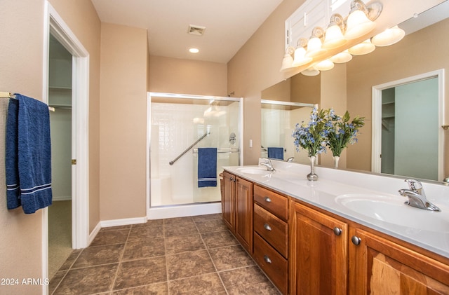 bathroom featuring tile patterned flooring, vanity, and a shower with door