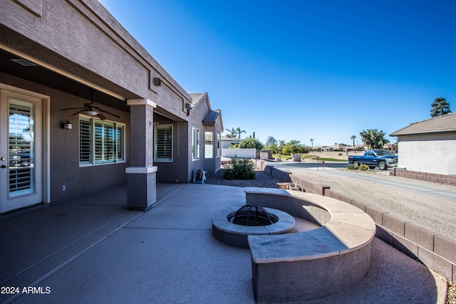 view of patio with ceiling fan and a fire pit