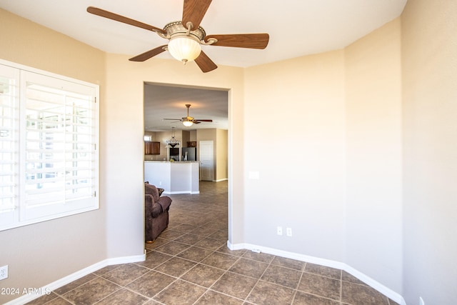 tiled empty room featuring ceiling fan