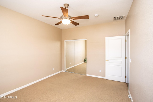 unfurnished bedroom with ceiling fan, a closet, and carpet