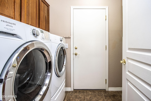 laundry room featuring dark tile patterned floors, cabinets, and independent washer and dryer