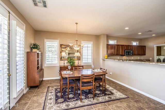 dining room with an inviting chandelier and washing machine and clothes dryer