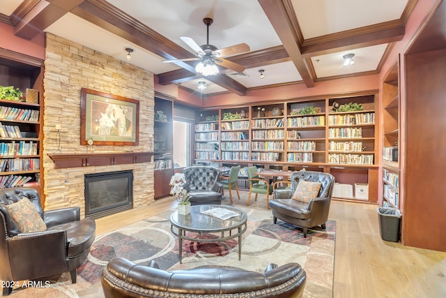 sitting room featuring beamed ceiling, ceiling fan, a fireplace, wood-type flooring, and coffered ceiling