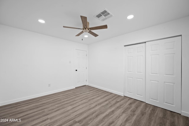 unfurnished bedroom featuring ceiling fan, a closet, and wood-type flooring