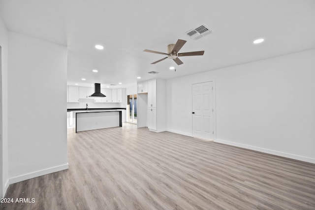 unfurnished living room with light hardwood / wood-style floors, ceiling fan, and sink