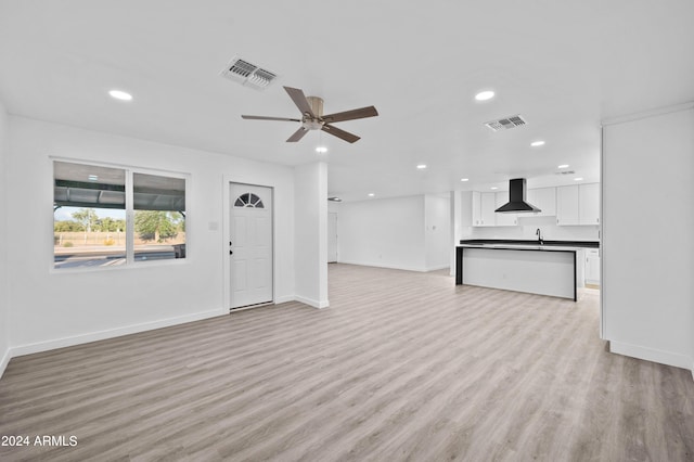 unfurnished living room with light hardwood / wood-style floors, ceiling fan, and sink