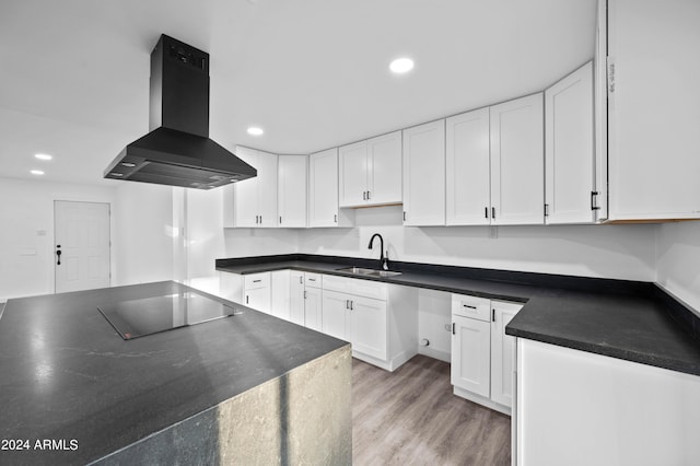 kitchen with ventilation hood, white cabinets, sink, and black cooktop