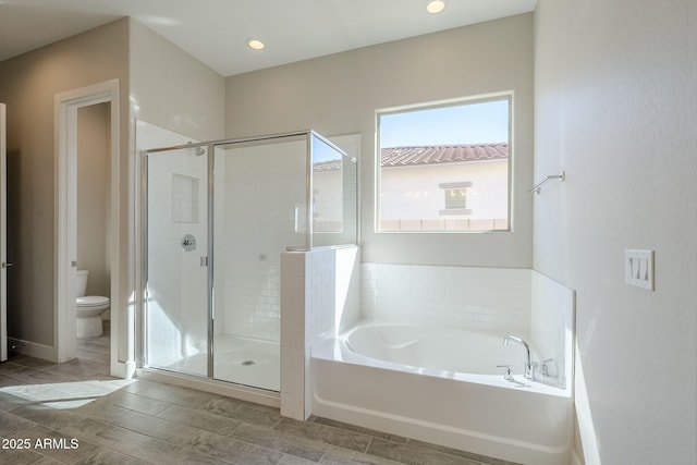 bathroom with toilet and shower with separate bathtub