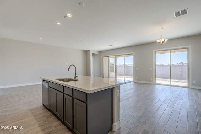 kitchen featuring sink, a kitchen island with sink, hanging light fixtures, a healthy amount of sunlight, and stainless steel dishwasher