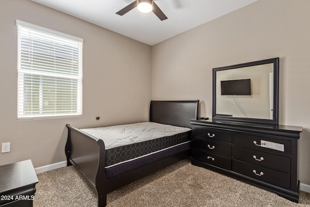 bedroom with ceiling fan, multiple windows, and light carpet