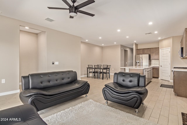 living room featuring ceiling fan and light hardwood / wood-style flooring