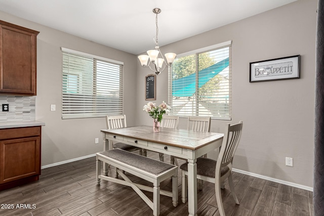 dining space featuring an inviting chandelier, a wealth of natural light, and dark hardwood / wood-style floors