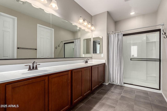 bathroom with a shower with door, vanity, and tile patterned floors