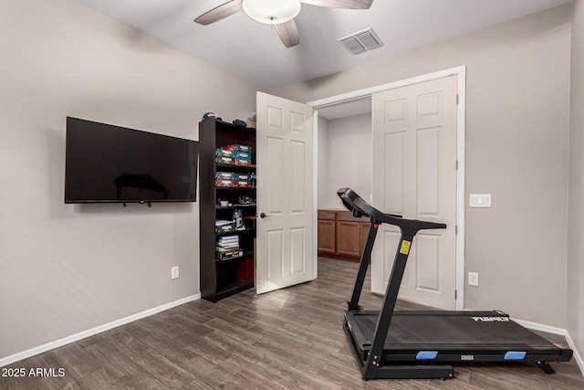 exercise area with dark wood-type flooring and ceiling fan