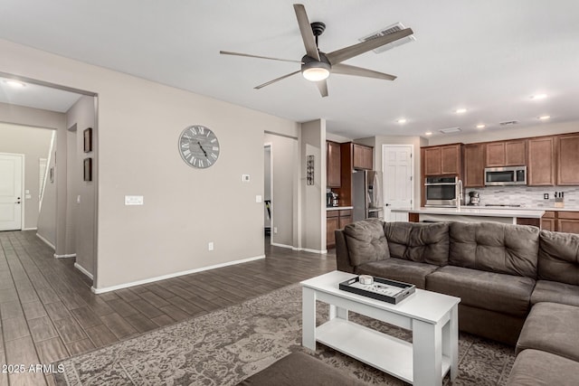 living room featuring dark hardwood / wood-style flooring and ceiling fan