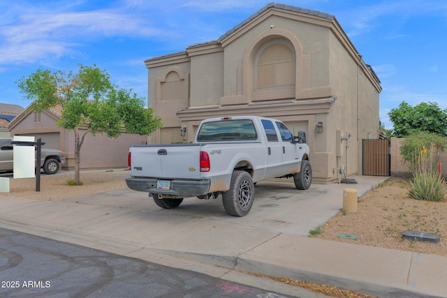 exterior space featuring fence, a gate, and concrete driveway