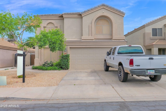 view of front of house featuring an attached garage, stucco siding, a tile roof, and concrete driveway