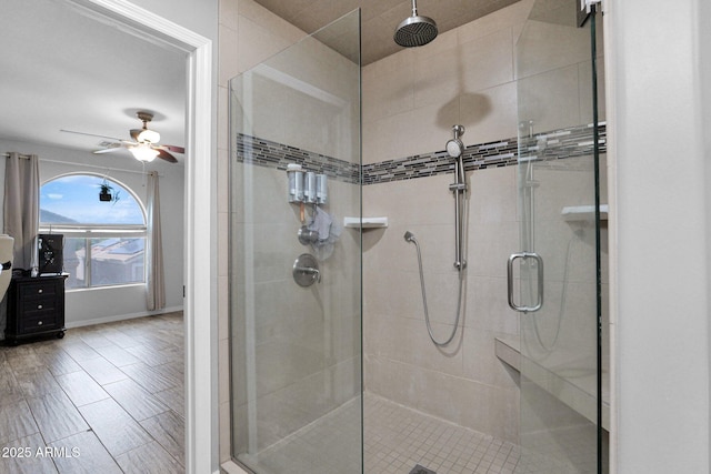 full bath with baseboards, ceiling fan, and a stall shower