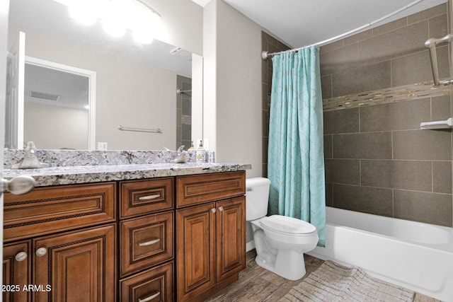 bathroom with vanity, visible vents, toilet, and shower / tub combo