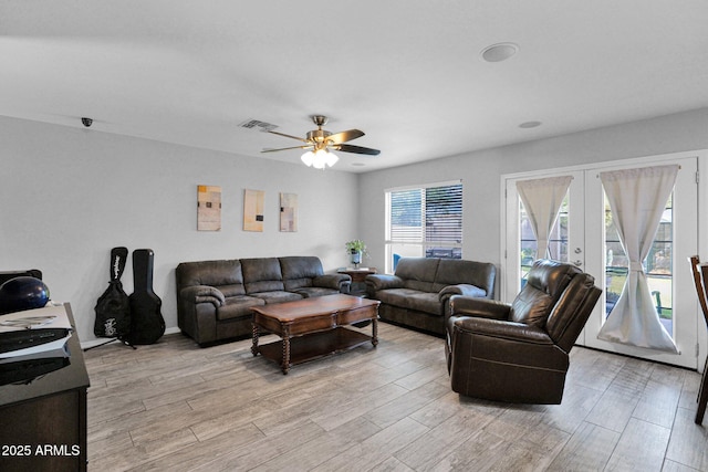 living room with ceiling fan, visible vents, french doors, and light wood-style floors