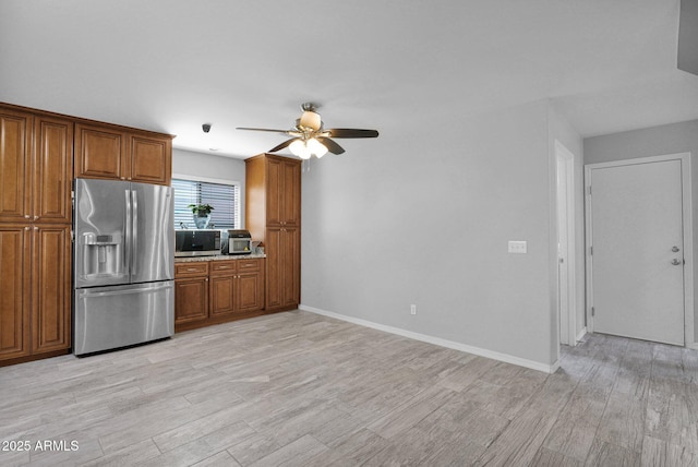 kitchen featuring ceiling fan, brown cabinetry, stainless steel appliances, and light wood finished floors