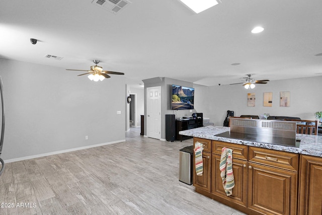 kitchen featuring ceiling fan, visible vents, and open floor plan