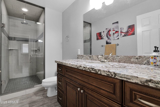 full bathroom with vanity, a stall shower, and toilet