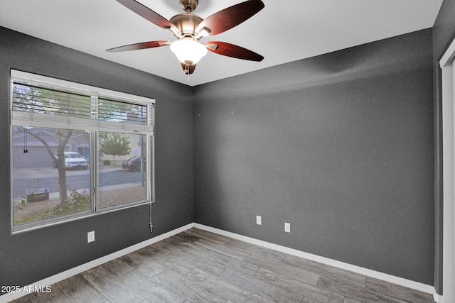 unfurnished room featuring baseboards, a ceiling fan, and wood finished floors