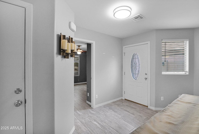 foyer entrance with baseboards, visible vents, and light wood-style flooring