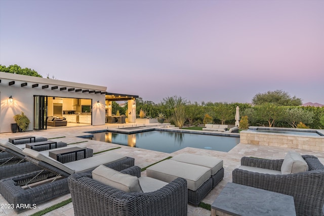 pool at dusk with a patio, an in ground hot tub, and an outdoor living space