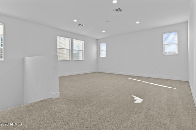 carpeted spare room featuring recessed lighting, visible vents, and baseboards