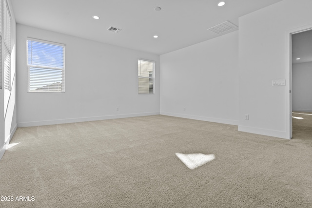 spare room with recessed lighting, visible vents, baseboards, and light colored carpet