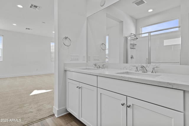 bathroom with a sink, visible vents, and a shower stall