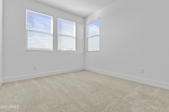 empty room featuring baseboards and carpet floors