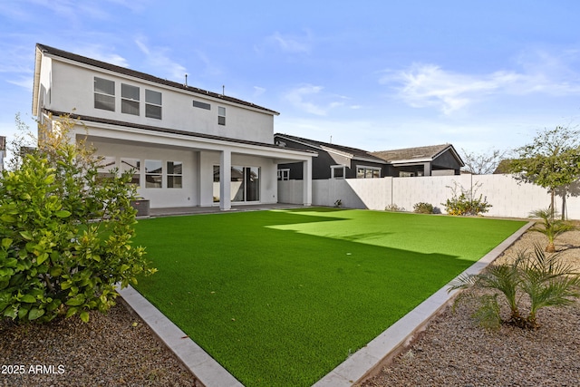 rear view of property with a patio area, a fenced backyard, a lawn, and stucco siding