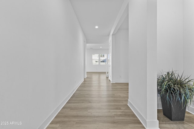 hall featuring recessed lighting, light wood-style floors, and baseboards