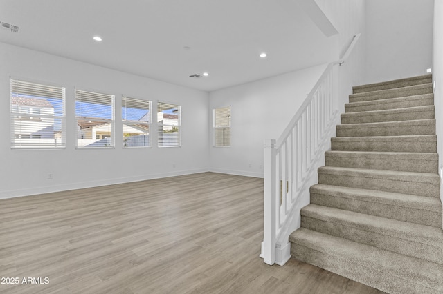 interior space with light wood finished floors, visible vents, recessed lighting, and stairs